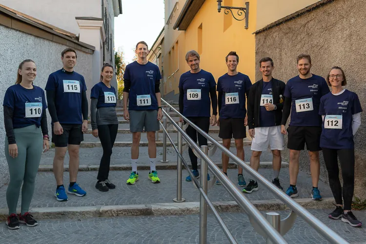 Sieben Mitglieder des Kärntner Landesrechnungshofs bereit für den Businesslauf in Sportkleidung und mit Startnummern auf den Shirts.